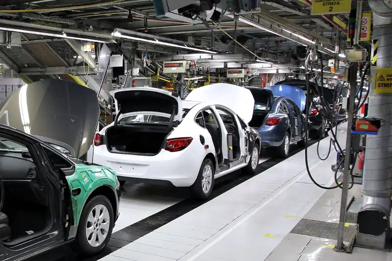 Línea de ensamble automotriz con carrocerías en proceso dentro de una planta