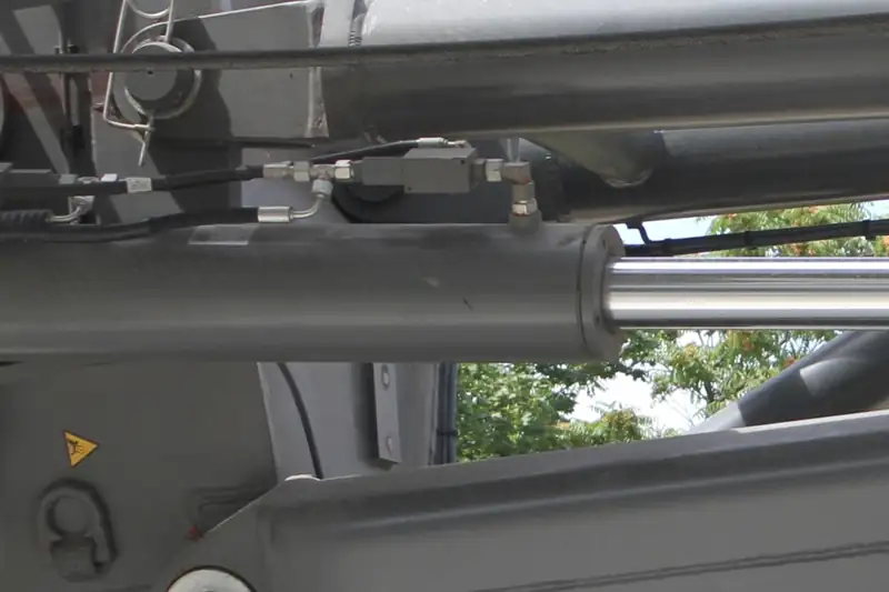 Detalle de cilindros hidráulicos y mangueras en el brazo de una máquina