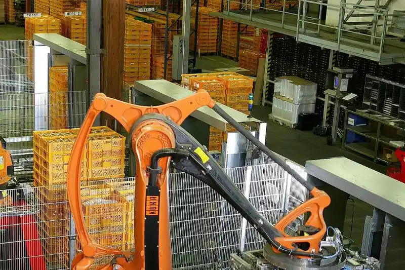 Robot industrial paletizando cajas en una planta automatizada