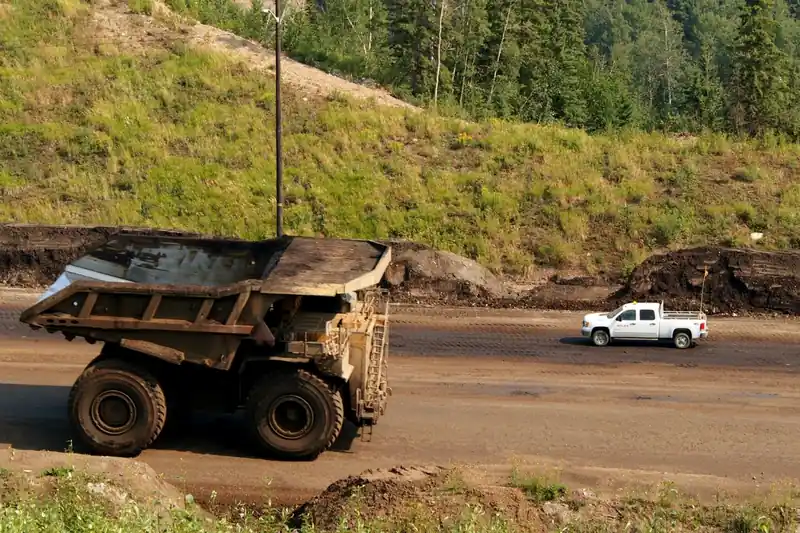 Camión minero de gran tonelaje junto a una camioneta en una operación a cielo abierto