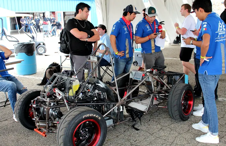 Equipo trabajando alrededor del chasis rodante en el paddock